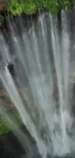 Majestic waterfall surrounded by greenery cascading down.