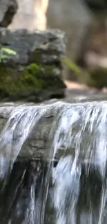 Serene waterfall over rocks with lush moss.