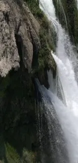 Stunning waterfall flowing over rugged rocks with lush greenery.