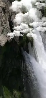 Serene waterfall cascading over rocky cliffs in a tranquil natural setting.