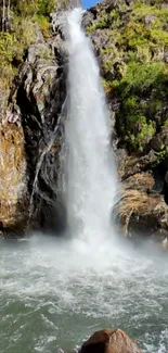 Peaceful waterfall amidst rocky scenery for mobile wallpaper.