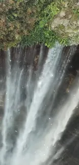 Cascading waterfall with lush greenery, perfect for a calming mobile wallpaper.