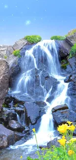 A serene waterfall surrounded by rocks, flowers, and vibrant greenery under a blue sky.