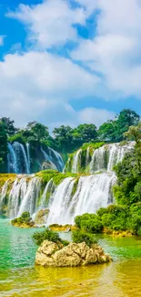 Serene waterfall with lush greenery under a bright blue sky.