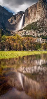 Serene mountain landscape with waterfall reflection in a tranquil lake.