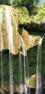 Lush green cliff with cascading waterfall scene.