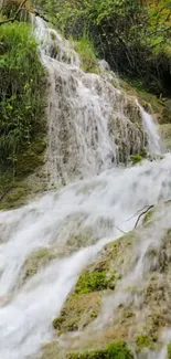 Beautiful waterfall with lush green scenery under a bright blue sky.