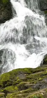 Serene waterfall flowing over mossy rocks.