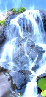 Beautiful waterfall with blue sky backdrop and lush greenery.