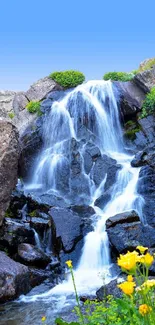 A serene waterfall cascades amid rocky cliffs with vibrant flowers.