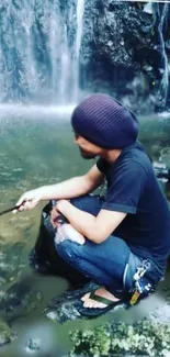 Person sitting near a tranquil waterfall in nature.