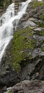 Waterfall cascading over mossy rocks in a scenic natural setting.