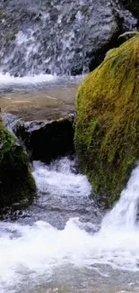 Waterfall with mossy rocks and flowing stream, nature wallpaper.