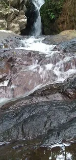 Serene waterfall stream flowing over rocks, offering a tranquil nature view.