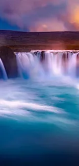 Serene waterfall at sunset with blue water and orange skies.