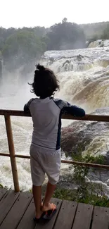 Rear view of a child watching a waterfall.