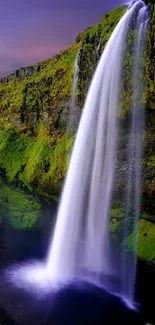 A serene waterfall cascading over vibrant green cliffs at sunset.