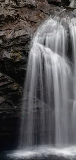 Serene waterfall with lush greenery on rocky cliffs.