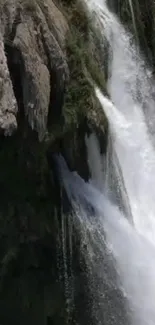 Waterfall cascading over rugged cliffs with white frothy water.