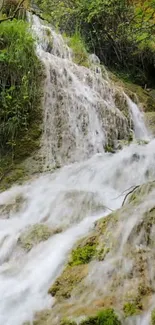 Serene waterfall with lush greenery cascading down rocks.