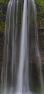 A serene waterfall flowing gently against a rocky backdrop.