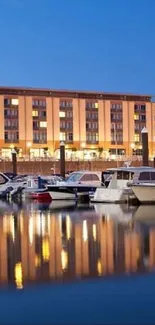 Serene waterfront view with boats and lit building at dusk.