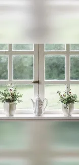 Window sill with flowers and teapot against lush greenery.