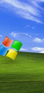 A lush green hill under a vibrant blue sky with a Windows logo.