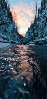 Tranquil river flowing through a snowy winter gorge at sunset.