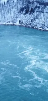 Snowy river with icy blue water in a serene winter landscape.