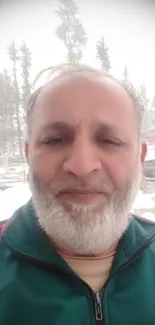 Man standing in snowy landscape with trees.