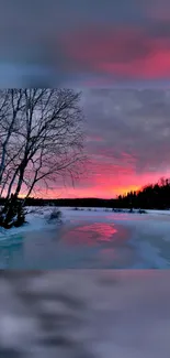 Vibrant winter sunset over a frozen lake with trees.