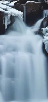 Serene winter waterfall surrounded by ice and snow-covered rocks.