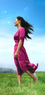 A woman in a pink dress walking through a green field under a clear blue sky.