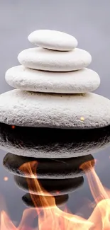 Zen stones stacked over reflective surface in a minimalist design.