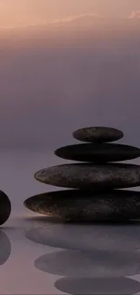 Serene zen stones stacked against a purple sunset sky.