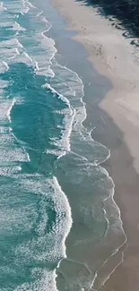 Aerial view of turquoise ocean waves on a sandy beach, exuding tranquility and beauty.