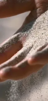 Close-up of hand releasing sand, creating a serene and calming effect.