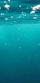 Serene underwater view with bubbles in teal blue sea.