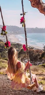 Woman on a swing overlooking a beach and ocean.