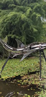 Sculpture of a shark in a lush green pond with water lilies.