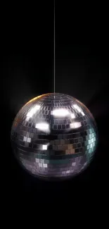 Shimmering silver disco ball against a dark background.