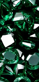 Beautiful emerald gemstones in various cuts shimmering on a dark background.