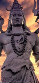 Majestic Shiva statue set against a vibrant sunset backdrop.