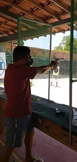 Man aiming a pistol at a shooting range in action.