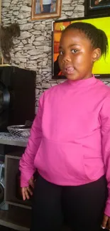 Young child in pink sweater standing in cozy room.