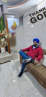 Sikh man relaxing on a couch in a stylish room with 'Thank God' text.