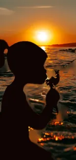 Child's silhouette on beach at sunset, vibrant sunset horizon.