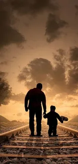 Silhouette of father and child on railway tracks with a sunset backdrop.