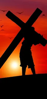 Silhouette carrying cross at sunset with birds in the sky.